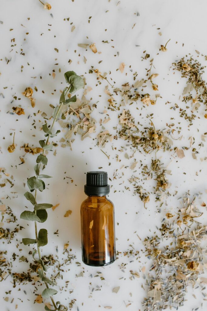 Amber glass bottle surrounded by dried herbs, ideal for holistic health and wellness themes.